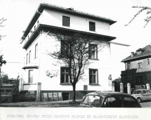 Stara fotografija stavbe ZDSSS na Groharjevi 2, pod njo obledel napis: Poslovna stavba Zveze društev slepih in slabovidnih Slovenije